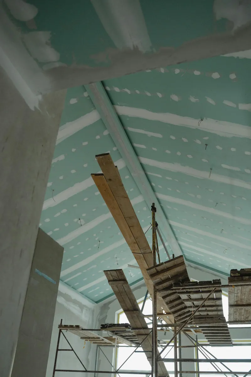 A rough interior wall mid-renovation with unfinished drywall seams.